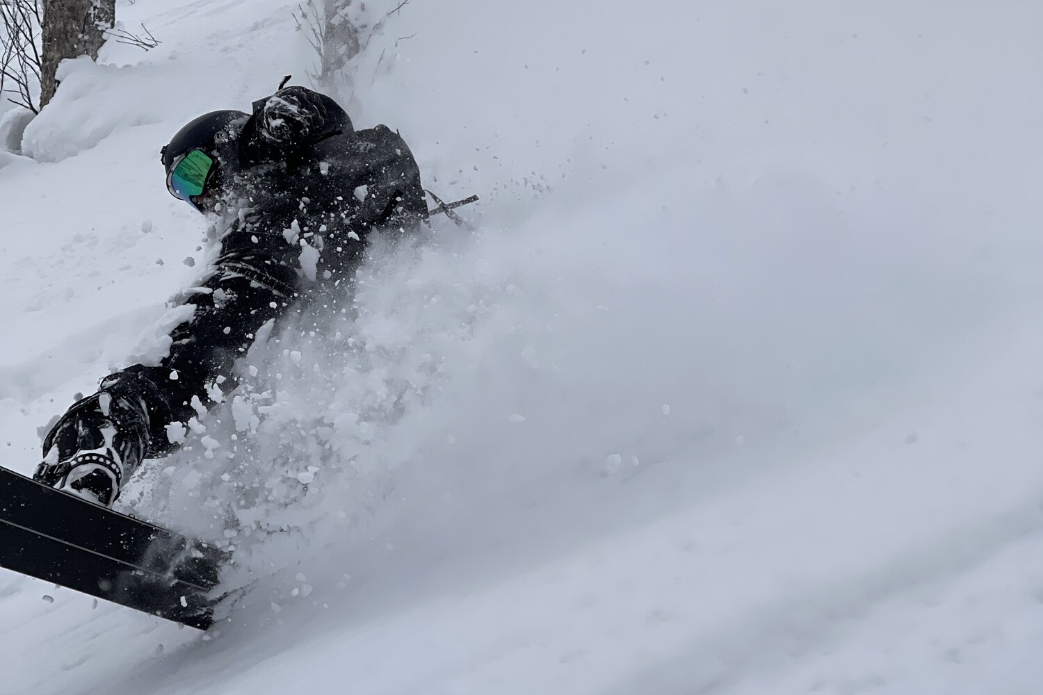 Snowboarder in a face-shot of deep Japan powder — the classic white room
